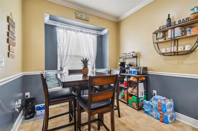 dining space featuring tile patterned flooring, ornamental molding, and baseboards