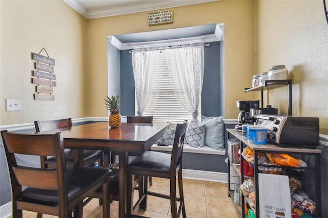 dining room featuring light tile patterned floors, baseboards, and crown molding