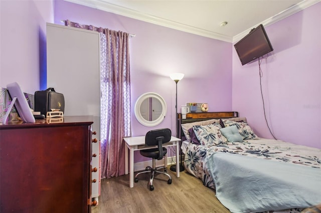 bedroom featuring crown molding and wood finished floors