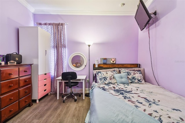 bedroom featuring crown molding and wood finished floors