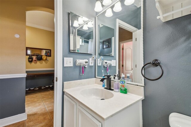 bathroom with crown molding, vanity, toilet, and tile patterned floors