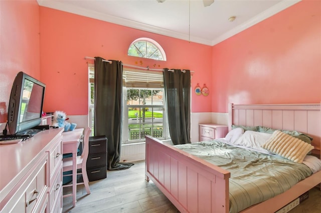 bedroom with light wood finished floors and crown molding