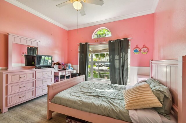 bedroom with light wood-style floors, crown molding, and a ceiling fan