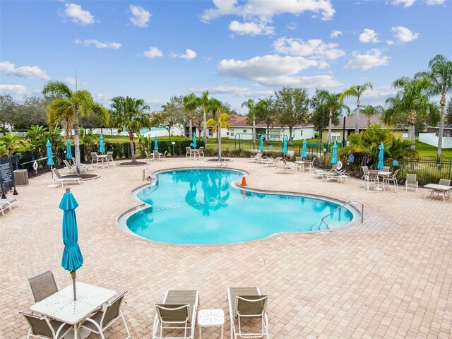 community pool featuring a patio area and fence