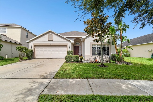 ranch-style home featuring an attached garage, driveway, a front lawn, and stucco siding