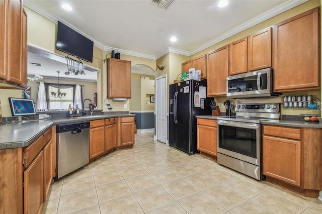 kitchen with arched walkways, light tile patterned flooring, a sink, appliances with stainless steel finishes, and dark countertops