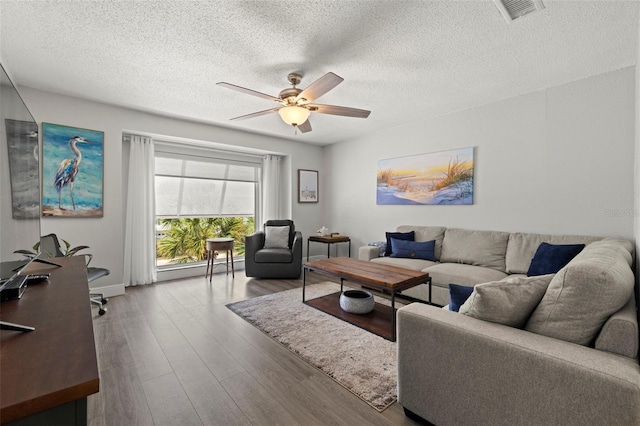 living room featuring a textured ceiling, light hardwood / wood-style flooring, and ceiling fan