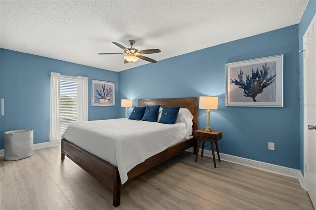 bedroom featuring a textured ceiling, light hardwood / wood-style flooring, and ceiling fan