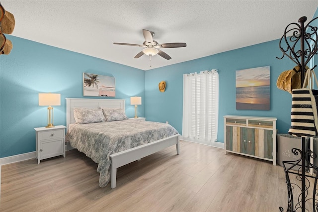 bedroom featuring a textured ceiling, ceiling fan, and light hardwood / wood-style floors