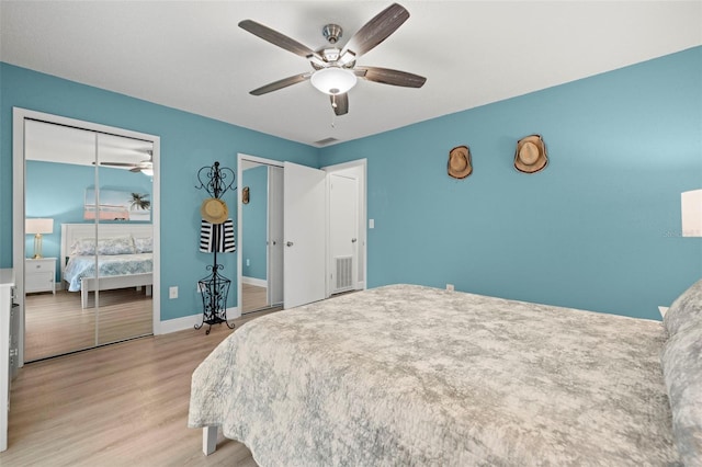 bedroom featuring light wood-type flooring, two closets, and ceiling fan