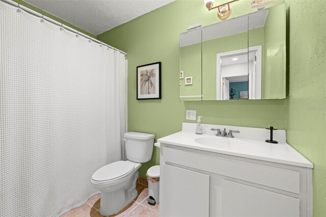 bathroom featuring tile patterned flooring, toilet, a textured ceiling, and vanity