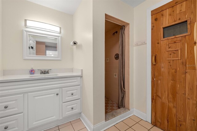 bathroom featuring tiled shower, tile patterned flooring, and vanity