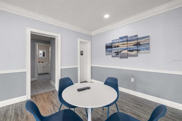 living area featuring wood-type flooring, a textured ceiling, and ornamental molding