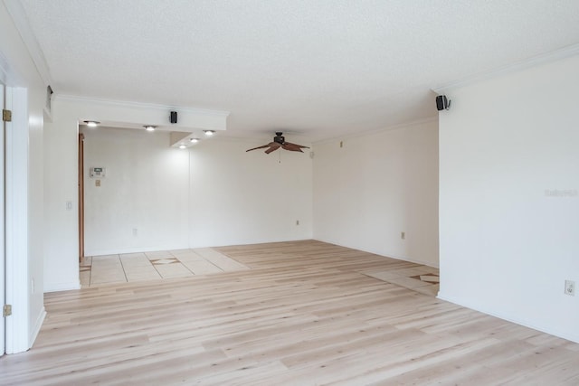 empty room featuring a textured ceiling, ceiling fan, ornamental molding, and light hardwood / wood-style floors