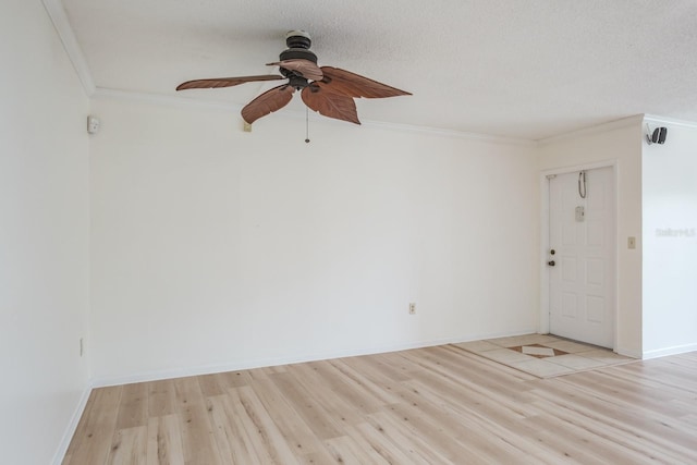 spare room featuring a textured ceiling, light hardwood / wood-style flooring, ceiling fan, and crown molding