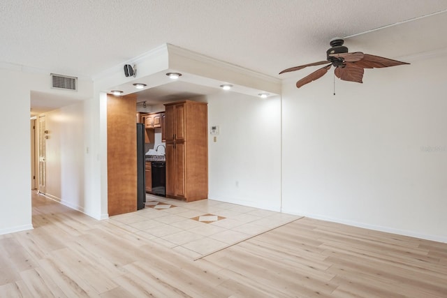 unfurnished room featuring ceiling fan, sink, a textured ceiling, and light hardwood / wood-style flooring