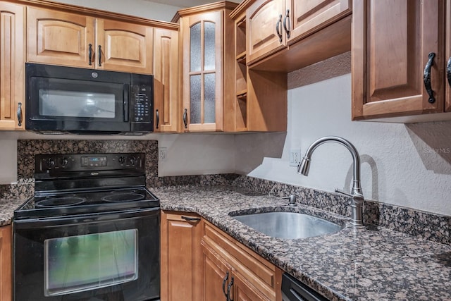 kitchen with black appliances, dark stone countertops, and sink