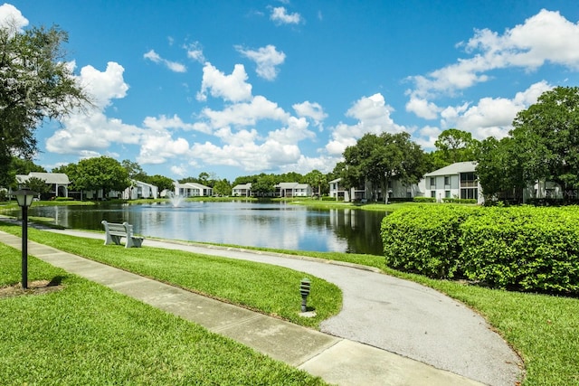 view of home's community featuring a water view and a yard