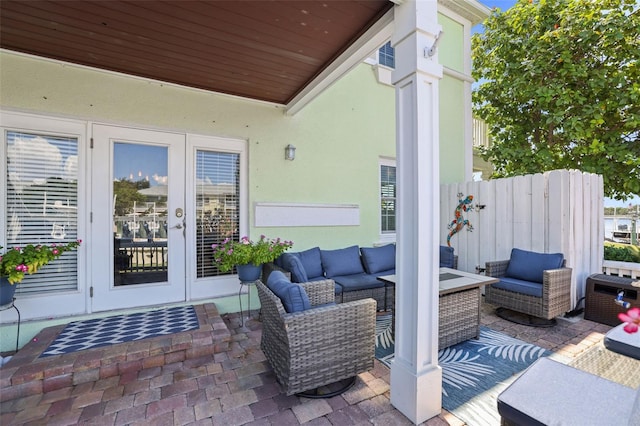 view of patio featuring french doors, outdoor lounge area, and fence