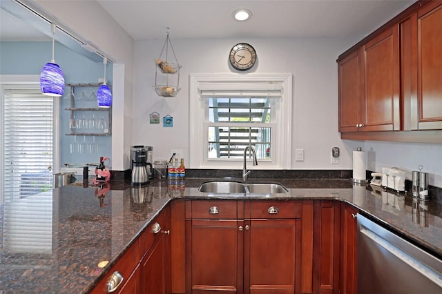 kitchen with a sink, dark stone countertops, brown cabinets, and dishwasher