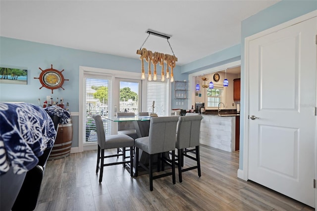 dining space with a chandelier, wood finished floors, and baseboards