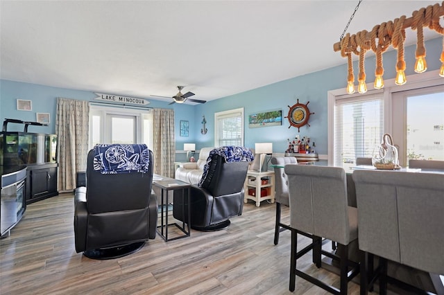 living area with a ceiling fan and wood finished floors