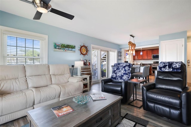 living room featuring dark wood-type flooring and a ceiling fan