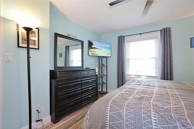 bedroom featuring ceiling fan, baseboards, and wood finished floors