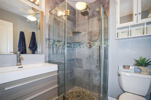 bathroom with ceiling fan, a stall shower, vanity, and toilet