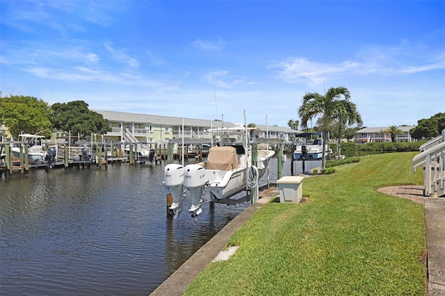 dock area featuring a water view, boat lift, and a lawn