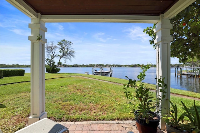 view of yard with a water view and a dock