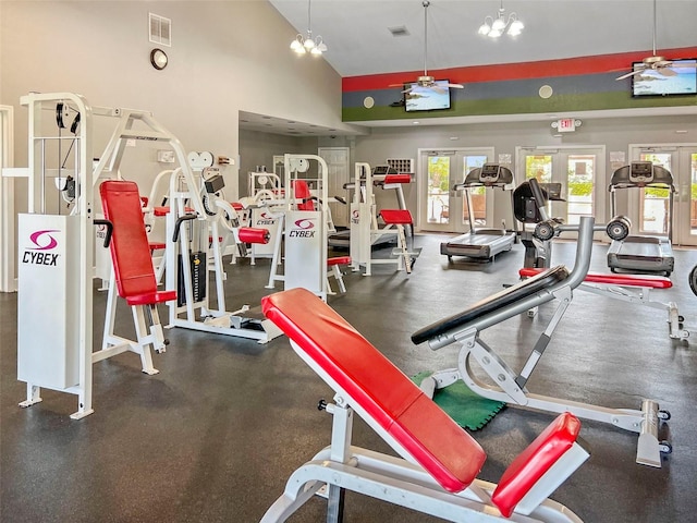 workout area with ceiling fan with notable chandelier, high vaulted ceiling, french doors, and visible vents