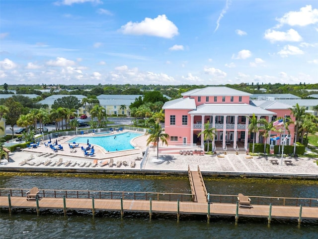 back of house with a patio area, a water view, and a community pool