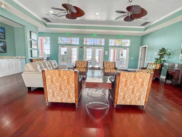 living room with dark wood-style floors, a tray ceiling, and french doors