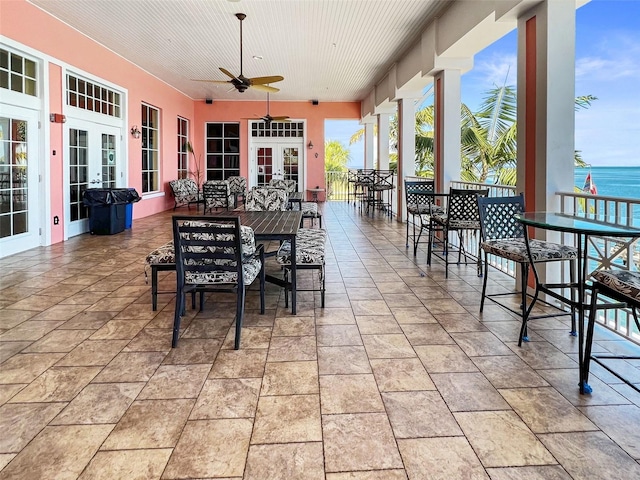 view of patio featuring outdoor dry bar, french doors, outdoor dining area, and a ceiling fan