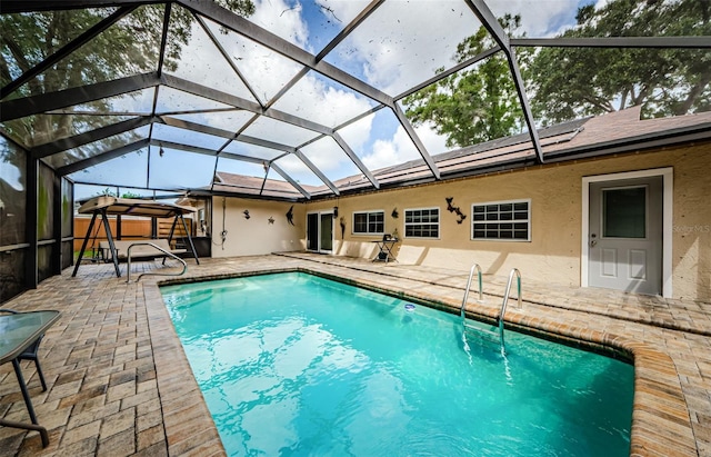 view of swimming pool featuring a lanai and a patio area