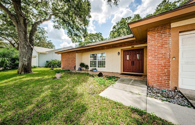 2208 Citrus Valley Cir, Palm Harbor, FL 34683 - doorway to property featuring a lawn, stucco siding, an attached garage, and brick siding