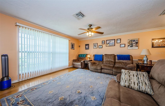 living room with ceiling fan, a textured ceiling, crown molding, and hardwood / wood-style floors