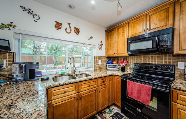 2208 Citrus Valley Cir, Palm Harbor, FL 34683 - kitchen featuring black appliances, light stone counters, a sink, and brown cabinetry