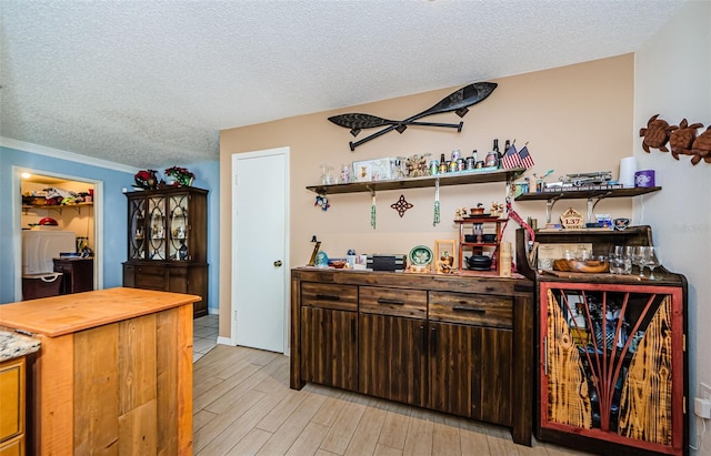 2208 Citrus Valley Cir, Palm Harbor, FL 34683 - bar with a textured ceiling, light wood-style flooring, and ornamental molding