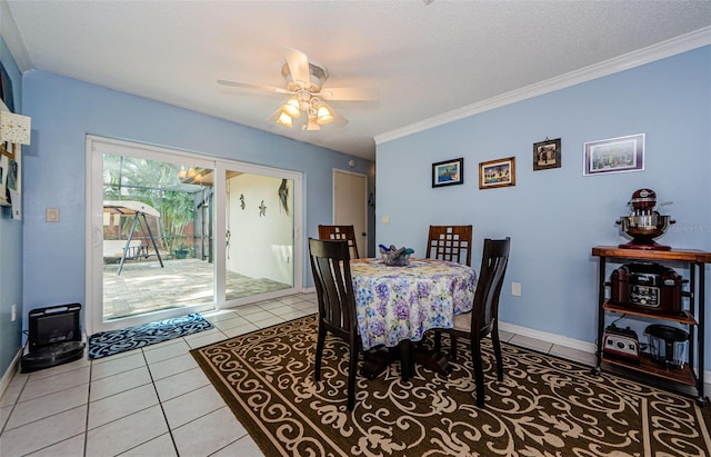 tiled dining area featuring a textured ceiling, crown molding, and ceiling fan