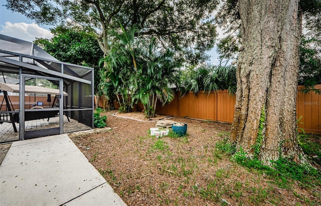2208 Citrus Valley Cir, Palm Harbor, FL 34683 - view of yard featuring glass enclosure, a fenced backyard, and a patio area