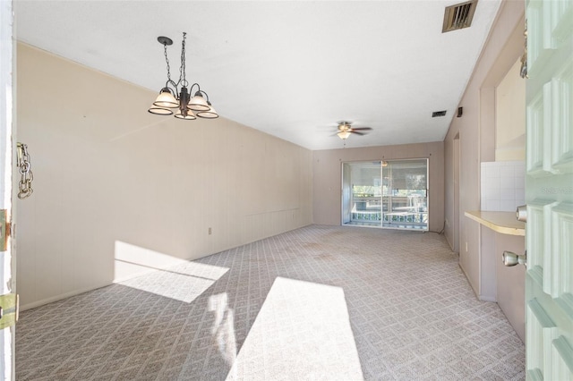 empty room featuring light colored carpet and ceiling fan with notable chandelier