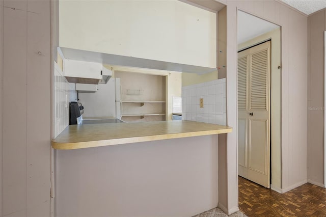 kitchen featuring stainless steel range oven and dark parquet flooring