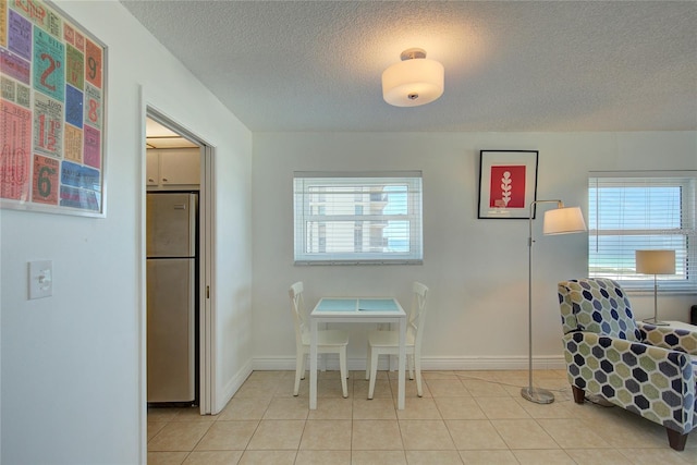 dining room featuring a textured ceiling and light tile patterned floors