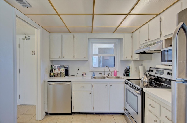 kitchen featuring light tile patterned flooring, appliances with stainless steel finishes, white cabinetry, and sink