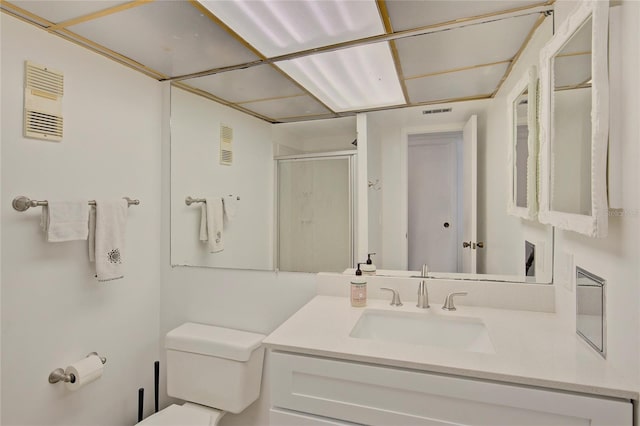 bathroom with a shower with shower door, toilet, and vanity