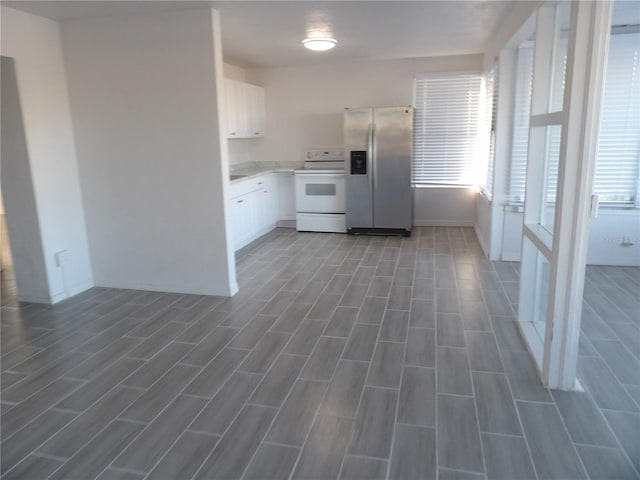 kitchen with stainless steel refrigerator with ice dispenser, dark hardwood / wood-style flooring, white range with electric stovetop, and white cabinets