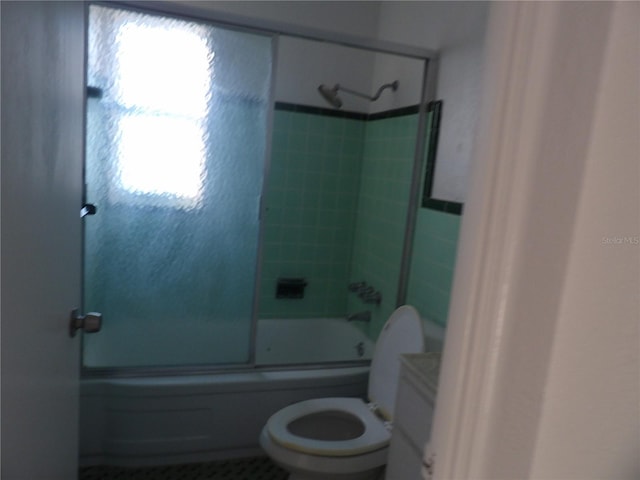 full bathroom featuring combined bath / shower with glass door, vanity, and toilet