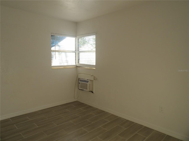 unfurnished room with a wall unit AC and dark hardwood / wood-style flooring